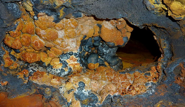 Goethite with vanadinite crystals in cavity.